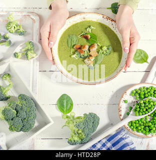 Frau Händen mit grünem Gemüse Suppe. Ansicht von oben Stockfoto