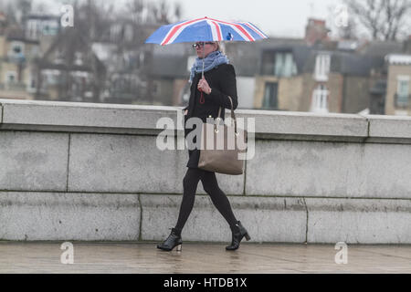 London UK. 10. März 2017. Ein Fußgänger schützt vor dem Regen mit einem Union Jack Regenschirm auf Putney Bridge London Kredit: Amer Ghazzal/Alamy Live-Nachrichten Stockfoto