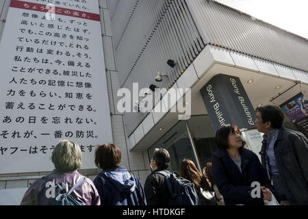 Tokyo, Tokyo, Japan. 11. März 2017. Leute schaut ein großes Plakat auf der Seite des Sony-Gebäudes in Ginza Marken den sechsten Jahrestag des 11. März 2011 Erdbeben und Tsunami Ginza, Tokio. Das Plakat wurde von Yahoo und zeigt die fragt Passanten, erinnere mich an die Katastrophe und die fast 18.000 Menschen, die gestorben. die Zeile markiert in Rot zeigt die maximale Höhe des Tsunami 16,7 Meter in Ofunato in der Präfektur Miyagi. Die Plakatwand ist bis zum 12. März zu sehen. Bildnachweis: Alessandro Di Ciommo/ZUMA Draht/Alamy Live-Nachrichten Stockfoto