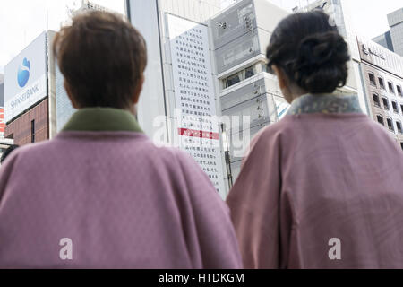 Tokyo, Tokyo, Japan. 11. März 2017. Zwei Frauen schauen Sie sich ein großes Plakat auf der Seite des Sony-Gebäudes in Ginza Marken den sechsten Jahrestag des 11. März 2011 Erdbeben und Tsunami Ginza, Tokio. Das Plakat wurde von Yahoo und zeigt die fragt Passanten, erinnere mich an die Katastrophe und die fast 18.000 Menschen, die gestorben. die Zeile markiert in Rot zeigt die maximale Höhe des Tsunami 16,7 Meter in Ofunato in der Präfektur Miyagi. Die Plakatwand ist bis zum 12. März zu sehen. Bildnachweis: Alessandro Di Ciommo/ZUMA Draht/Alamy Live-Nachrichten Stockfoto