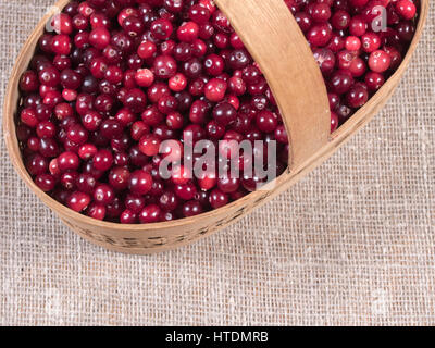 Preiselbeeren in einem Korb auf einem Hintergrund von Jute-Stoff. Stockfoto