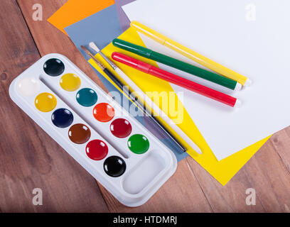 Reihe von Aquarellen, farbigen Blatt Papier und Pinsel auf einer Holzoberfläche Stockfoto