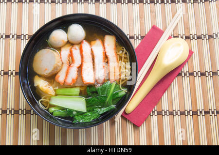 Ei Nudelsuppe mit roten Schweinebraten auf hölzernen Hintergrund. Stockfoto