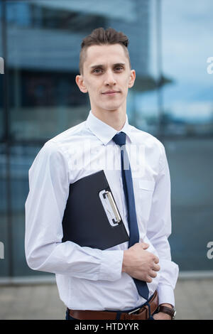 Städtische Unternehmen Mann Porträt draußen im Flughafen. Lässige jungen Geschäftsmann tragen Jackett. Hübscher Junge Manager mit in die Stadt. Stockfoto
