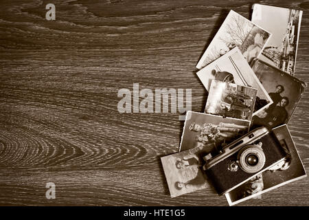 Vintage Messsucher-Kamera mit Fotografien auf einem hölzernen Hintergrund Stockfoto