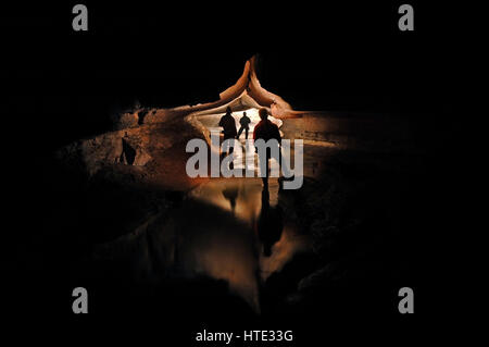 Höhlenforscher erkunden einen mystischen Höhle-Fluss Stockfoto