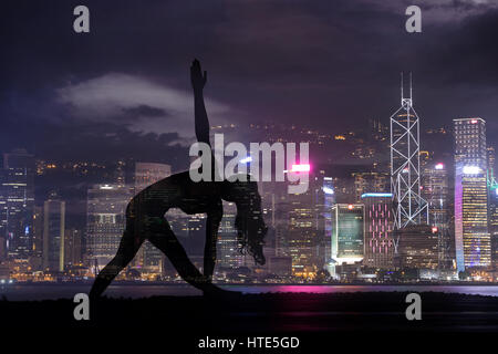 Doppelbelichtung Silhouette Yoga Frau gegen Hong Kong City bei Nacht Stockfoto