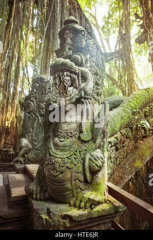 Skulpturen und Schnitzereien von Dämonen, Götter und balinesischen mythologischen Gottheiten auf Brücke in der Monkey Forest in Ubud, Bali. Stockfoto