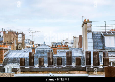 Rauch aus den Schornsteinen auf einem Paris Dach an einem bewölkten Tag Stockfoto
