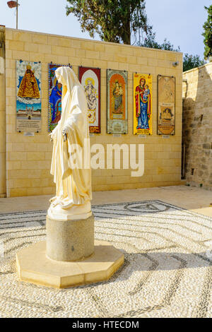 NAZARETH, ISRAEL - 16. Dezember 2015: Eine Statue der Maria, mit Spenden aus verschiedenen Nation im Hintergrund, in der Kirche der Mariä Verkündigung, Nazar Stockfoto