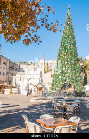 NAZARETH, ISRAEL - 23. Dezember 2013: Lokale und Besucher vor einem Weihnachtsbaum mit der Krippe, in der Nähe von der griechisch-orthodoxen Kirche von den Annunc Stockfoto