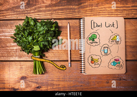 Leeres Notizbuch und Bleistift mit einem Bündel von Kräutern auf Holztisch Stockfoto