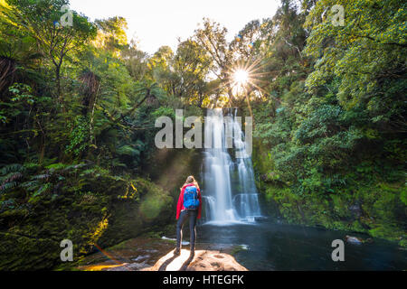 Wanderer vor McLean Wasserfall, Sun Star, die Catlins, Otago, Southland, Neuseeland Stockfoto