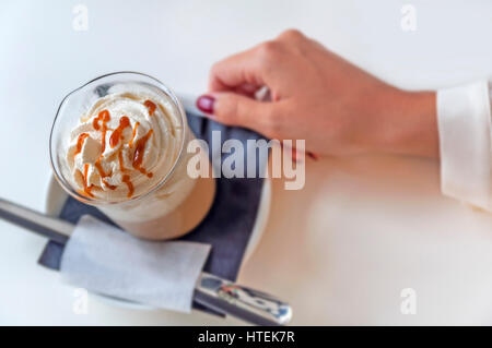 Ein frischer Caramel Latte mit Sahne auf Tisch im Café Tasse Stockfoto