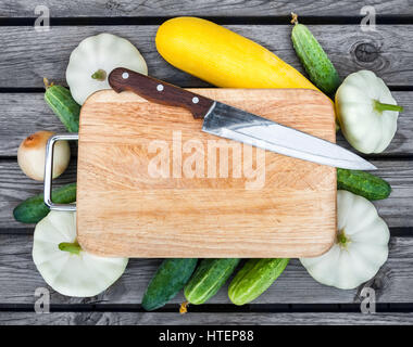 Schneidebrett, Messer, frisches Gemüse auf Holztisch.  Draufsicht mit Textfreiraum. Stockfoto