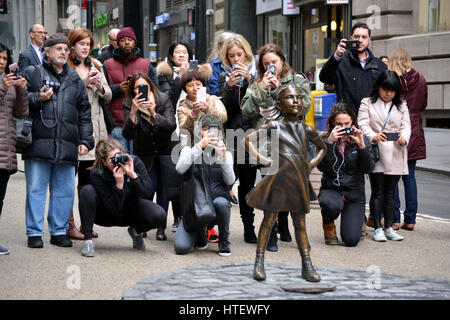 Menschen die Bilder von 'The Fearless Girl' Statue in Lower Manhattan. Stockfoto