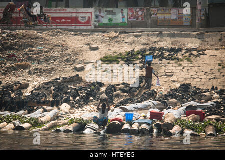 DHAKA, Bangladesch - Februar 2017: Mann Wäsche an den Ufern des Flusses in Dhaka, Bangladesch Stockfoto