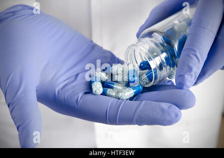 Person Pillen zum Ausgießen. Pille Arzt Hand Gießen Kapsel Flasche Closeup Pillen Konzept Stockfoto