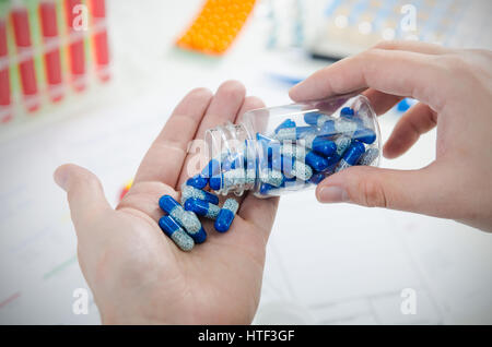 Person Pillen zum Ausgießen. Pille Arzt Hand Gießen Kapsel Flasche Closeup Pillen Konzept Stockfoto