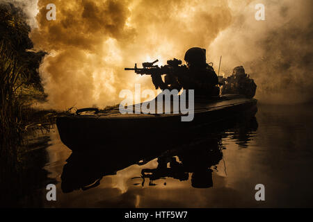 Beleuchtete Silhouette der Spezialeinheiten marine Betreiber in militärischen Kajak auf Feuer Explosion Hintergrund. Schlacht-Betrieb, Bomben explodierten Stockfoto