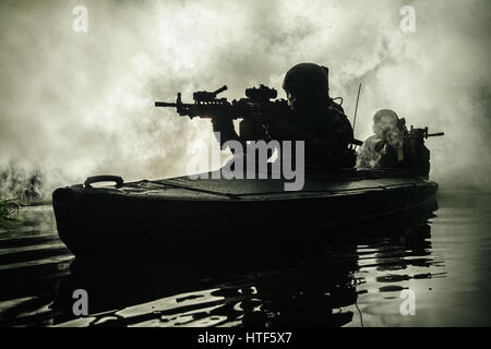 Beleuchtete Silhouette der Spezialeinheiten marine Betreiber in militärischen Kajak auf Feuer Explosion Hintergrund. Schlacht-Betrieb, Bomben explodierten Stockfoto