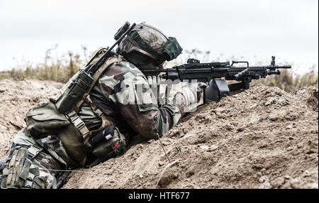 MG-Schütze des 1. Marine Infanterie Parachute Regiment RPIMA feuern von defensiven Position Graben, Profil-Seitenansicht Stockfoto