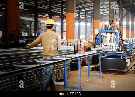 Stahlfabrik Fließband, Arbeiter in der nächsten Spritzgießen Ausrüstung. Stockfoto