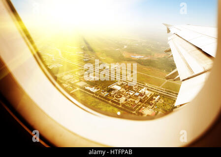 Wolken und Himmel gesehen durch Fenster eines Flugzeugs Stockfoto