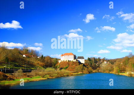 Burg auf dem Hügel, Fluss und blauer Himmel mit Wolken, Ozalj in Kroatien Stockfoto