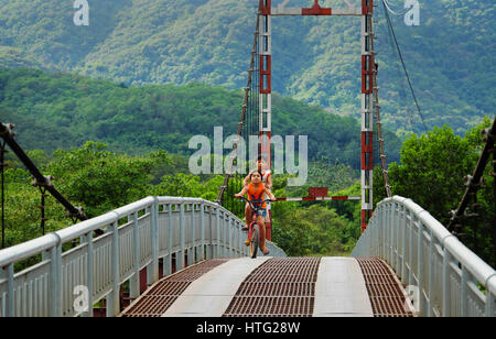 LAM DONG, VIET NAM - JAN 1, 2017: Gruppe von nicht identifizierten vietnamesische Kinder Fahrt Fahrrad cross Hängebrücke am Landschaft, schöne Szene mit g Stockfoto