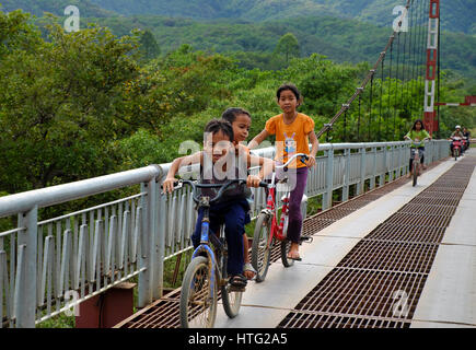 LAM DONG, VIET NAM - JAN 1, 2017: Gruppe von nicht identifizierten vietnamesische Kinder Fahrt Fahrrad cross Hängebrücke am Landschaft, schöne Szene mit g Stockfoto