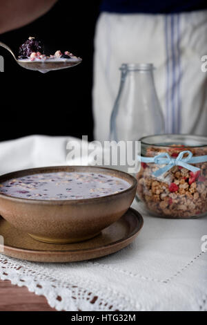 Milch Getreide in braune Schale. Portion Müsli auf einem Löffel Stockfoto