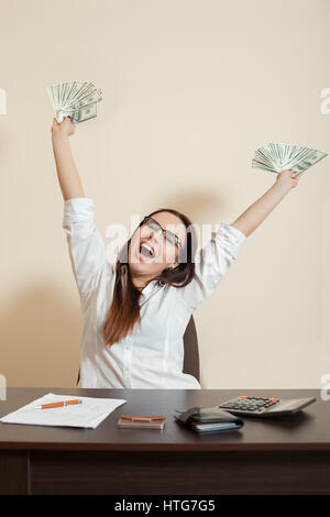 Lächelnd Geschäftsfrau wirft eine Packung von Dollar und Geld Regen zu machen. Stockfoto