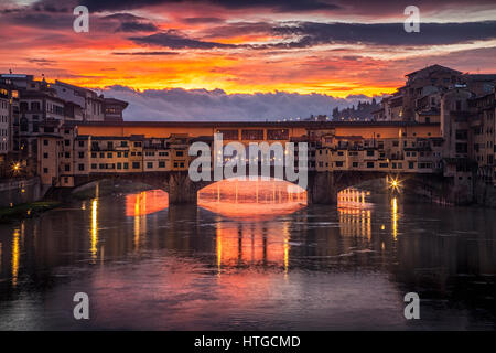 Clearing Gewitterwolken im Morgengrauen schaffen eine dramatische Sonnenaufgang über der Brücke Ponte Vecchio in Florenz, Italien Stockfoto