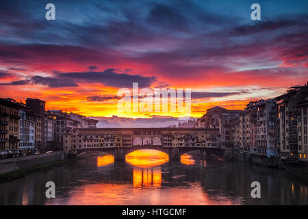 Clearing Gewitterwolken im Morgengrauen schaffen eine dramatische Sonnenaufgang über der Brücke Ponte Vecchio in Florenz, Italien Stockfoto