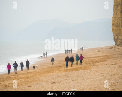 Burton Bradstock, Dorset, UK, 11. März 2017, Menschen am Strand Burton Bradstock Strand spazieren an einem dunstigen und nebligen Tag im West Dorset St Burton Bradstock Strand, Dorset, UK. © Dan Tucker/Alamy Live-Nachrichten Stockfoto