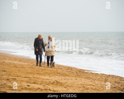 Burton Bradstock, Dorset, UK, 11. März 2017, zwei Frauen Spaziergang entlang des Strandes Burton Bradstock Strand an einem dunstigen und nebligen Tag im West Dorset St Burton Bradstock Strand, Dorset, UK. © Dan Tucker/Alamy Live-Nachrichten Stockfoto