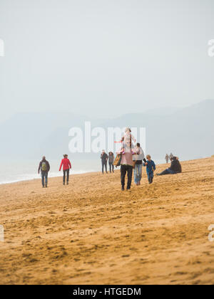 Burton Bradstock, Dorset, UK, 11. März 2017, Menschen am Strand Burton Bradstock Strand spazieren an einem dunstigen und nebligen Tag im West Dorset St Burton Bradstock Strand, Dorset, UK. © Dan Tucker/Alamy Live-Nachrichten Stockfoto