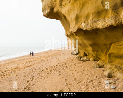 Burton Bradstock, Dorset, UK, 11. März 2017, Menschen am Strand Burton Bradstock Strand spazieren an einem dunstigen und nebligen Tag im West Dorset St Burton Bradstock Strand, Dorset, UK. © Dan Tucker/Alamy Live-Nachrichten Stockfoto