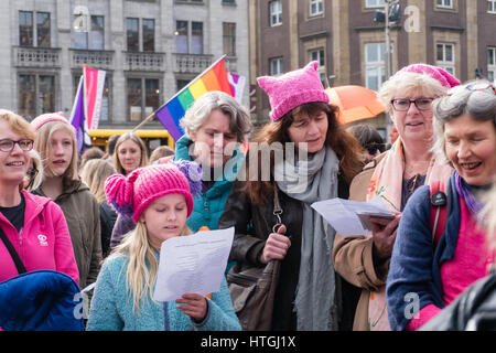 Amsterdam, Niederlande. 12. März 2017. Frauen der Pop-up-Frauen Chor Groningen, rosa Hüte tragen, singen Lieder, da immer mehr Menschen versammeln sich auf den Dam Square Kredit: Steppeland/Alamy Live News Stockfoto