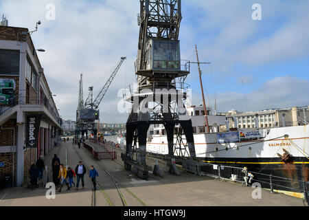 Bristol, UK. 15. März 2017. Großbritannien Wetter. Menschen schlendern Sie entlang der Docks an einem milden Tag wo wie Princes Wharf in A British WW11 Drama gedreht wird in Bristol großen Bildschirm eine andere Mütter Sohn genannt. Gefilmt von Balmoral am Kai und mit Hilfe von riesigen Kränen. Eine Sequenz für eine Kulisse in welche Jersey Deportierten an Bord eines Schiffes der 1940er Jahre Dampf gesetzt werden. Der Film eine andere Mütter Sohn in mehr als 100 öffnet Kinos große Nation am Freitag, den 24. März. Durch verbindliche / Line Robert Timoney/Alamy/Leben/News Stockfoto