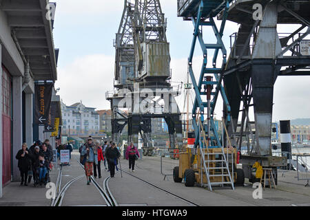 Bristol, UK. 15. März 2017. Großbritannien Wetter. Menschen schlendern Sie entlang der Docks an einem milden Tag wo wie Princes Wharf in A British WW11 Drama gedreht wird in Bristol großen Bildschirm eine andere Mütter Sohn genannt. Gefilmt von Balmoral am Kai und mit Hilfe von riesigen Kränen. Eine Sequenz für eine Kulisse in welche Jersey Deportierten an Bord eines Schiffes der 1940er Jahre Dampf gesetzt werden. Der Film eine andere Mütter Sohn in mehr als 100 öffnet Kinos große Nation am Freitag, den 24. März. Durch verbindliche / Line Robert Timoney/Alamy/Leben/News Stockfoto