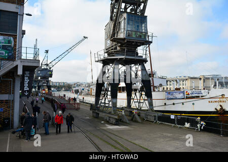 Bristol, UK. 15. März 2017. Großbritannien Wetter. Menschen schlendern Sie entlang der Docks an einem milden Tag wo wie Princes Wharf in A British WW11 Drama gedreht wird in Bristol großen Bildschirm eine andere Mütter Sohn genannt. Gefilmt von Balmoral am Kai und mit Hilfe von riesigen Kränen. Eine Sequenz für eine Kulisse in welche Jersey Deportierten an Bord eines Schiffes der 1940er Jahre Dampf gesetzt werden. Der Film eine andere Mütter Sohn in mehr als 100 öffnet Kinos große Nation am Freitag, den 24. März. Durch verbindliche / Line Robert Timoney/Alamy/Leben/News Stockfoto