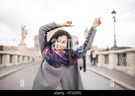 Glücklich fröhliche junge Frau mit Armen angehoben, auf Sant Angelo Brücke in Rom. Hintergrundbeleuchtung mit textfreiraum erschossen. Stockfoto