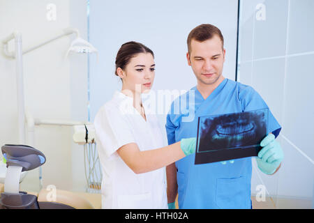 Zwei Ärzte Zahnarzt Blick auf eine Röntgenaufnahme im Amt. Stockfoto