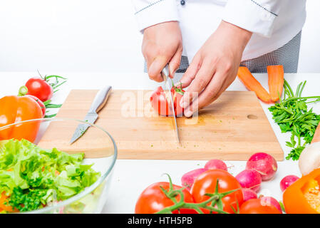 Tomaten auf ein Schneidebrett in den Händen des Küchenchefs Stockfoto
