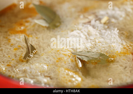 Pilaw-Reis mit Lorbeerblättern vorbereiten, Nahaufnahme Foto fallenden Stockfoto