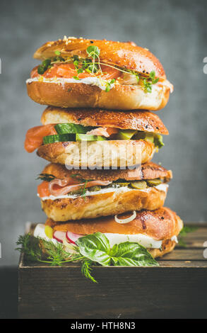 Haufen von Bagels mit Eiern, Gemüse, Kapern, Lachs und Frischkäse Stockfoto