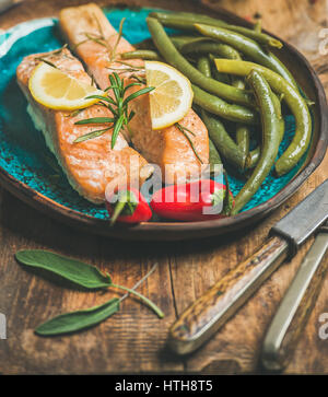 Gebratener Lachs mit Zitrone, Rosmarin, Chilischote und Bohnen Stockfoto