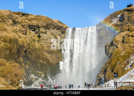 Wasserfall Skogafoss, Island, mit Regenbogen und blauer Himmel im Winter Stockfoto